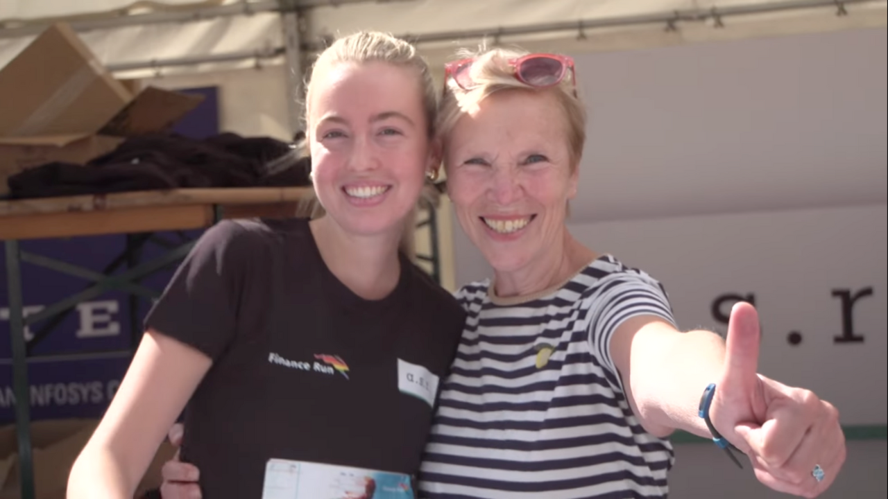 Two women on the finance run looking happy. One raises a thumb.